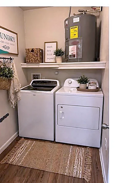 In-unit laundry room with washer, dryer, and built-in shelving
